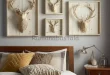 Empat dekorasi dinding kepala rusa artistik di atas tempat tidur bernuansa hangat dan earthy modern.
