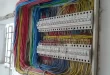 Panel listrik dengan kabel warna-warni tersusun rapi, menyembunyikan kabel dan colokan supaya rumah tetap rapi maksimal